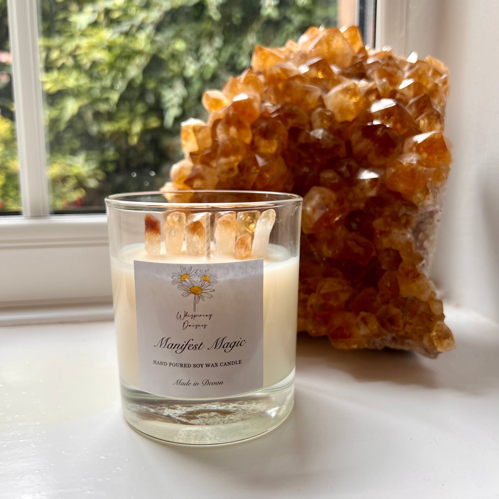 Manifest Magic Candle in a clear glass jar, topped with citrine crystal chips, handmade sherbet lemon soy candle by Whispering Daisies.